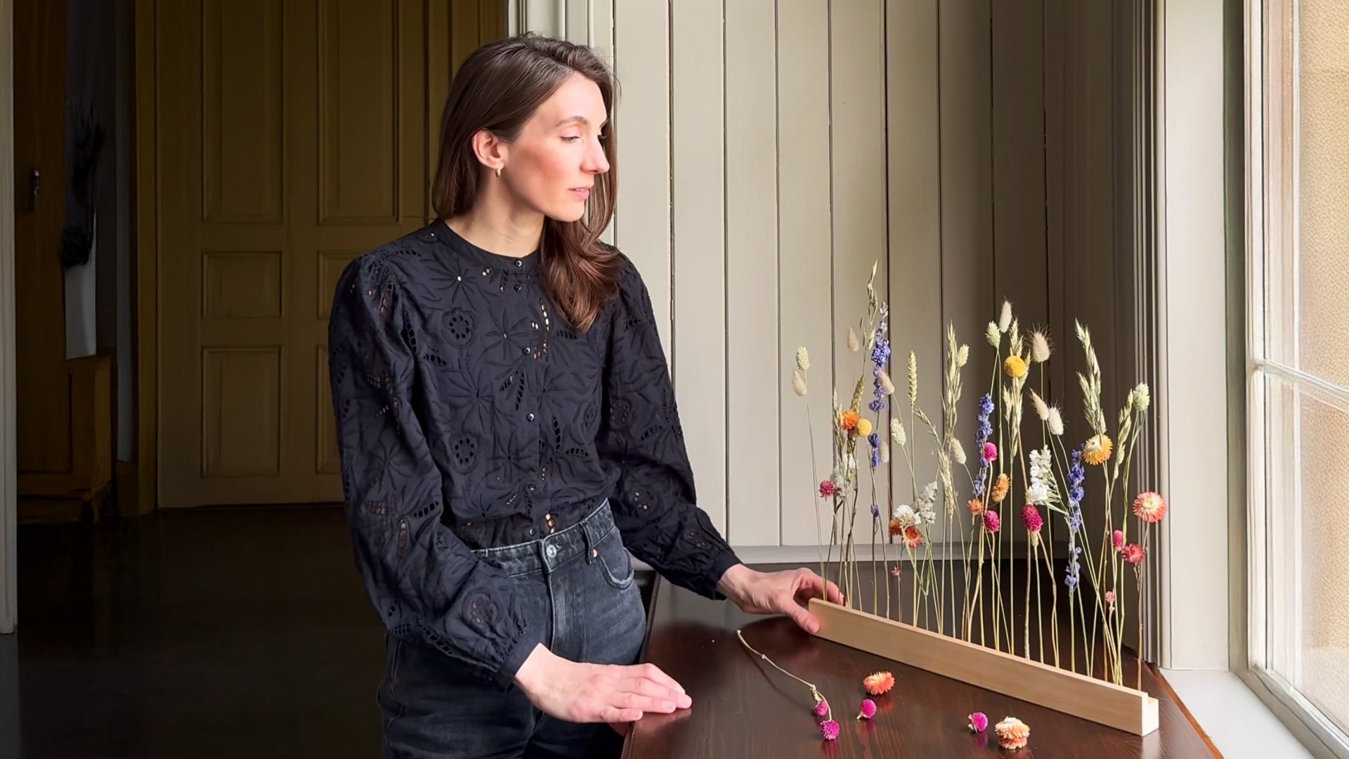 Blombruket Porträtt av kvinna som står vid arrangemang av torkade blommor
