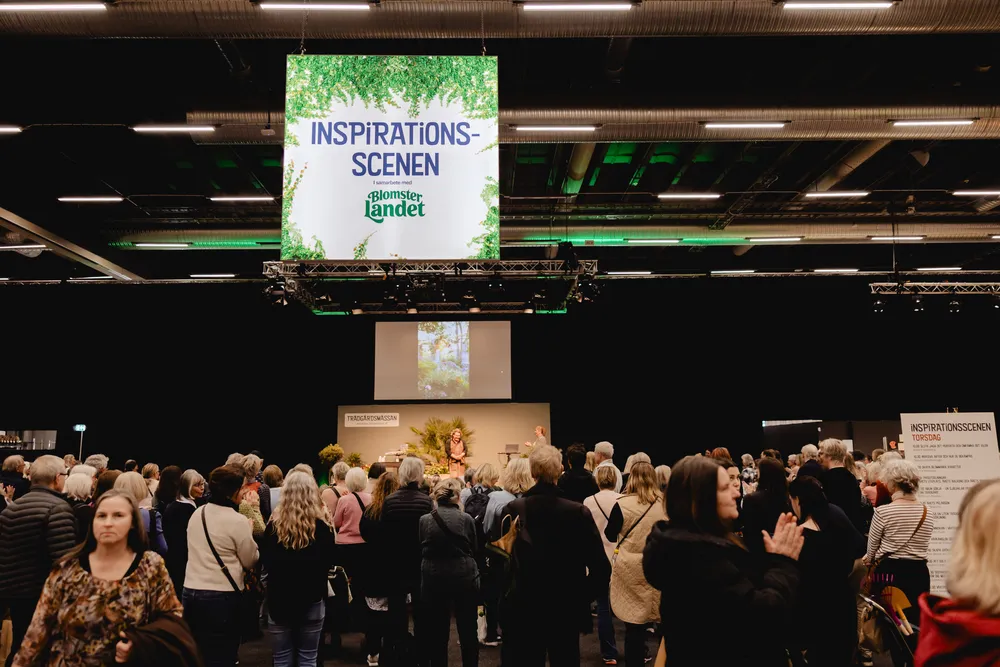 Trädgårdsmässan_fotograf_Angelica_Liljenroth-310 Mässmiljö med mycket folk och en stor skylt som det står Inspirationsscenen på.